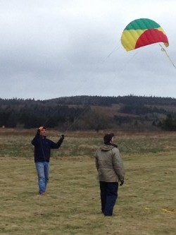 Scott launches a smaller kite while Ted looks on.